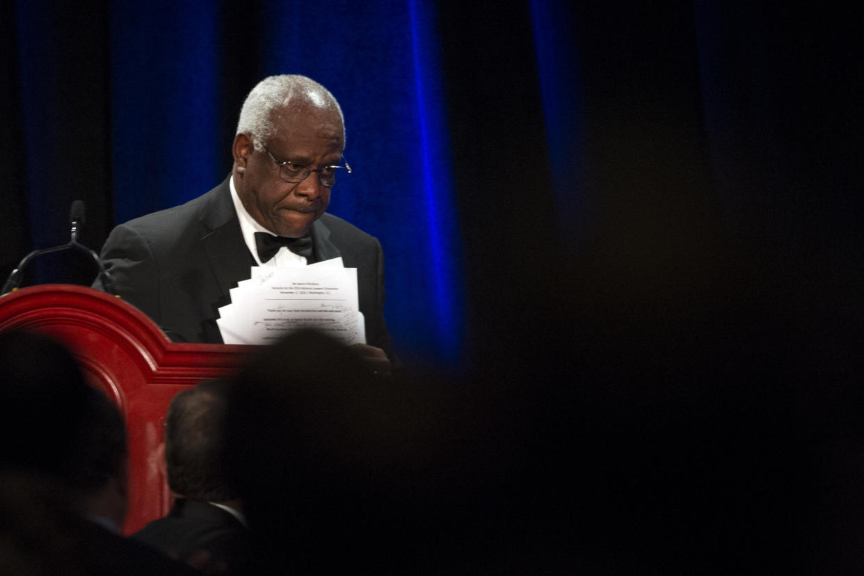 Supreme Court Justice Clarence Thomas gathers his papers as he leaves the podium after addressing the Federalist Society's National Lawyers Convention dinner at National Harbor, in Oxon Hill, MD, Thursday, Nov. 17, 2016. The convention is dedicated to the legacy of Supreme Court Associate Justice Antonin Scalia who died Feb 13, 2016. (AP Photo/Cliff Owen)