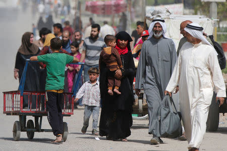 Displaced Iraqis walk as they flee after a battle between Iraqi rapid response forces and Islamic State militants in western Mosul, Iraq, April 22, 2017. REUTERS/Muhammad Hamed