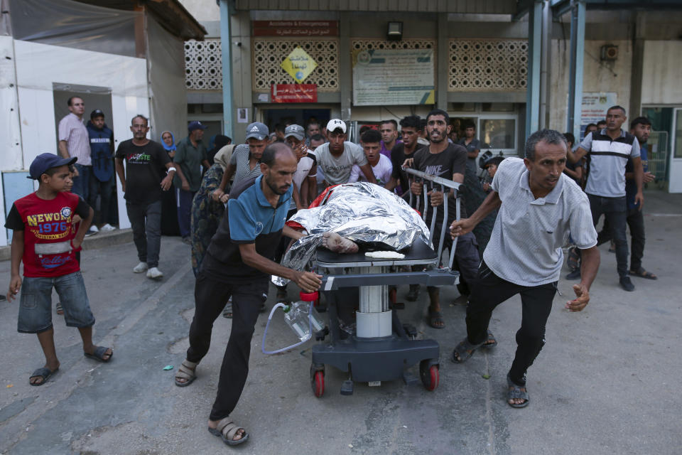 Palestinians carry the body of a man killed in the Israeli bombardment of the Gaza Strip to a hospital morgue in Khan Younis, southern Gaza Strip, Monday, June 24, 2024. (AP Photo/Jehad Alshrafi)