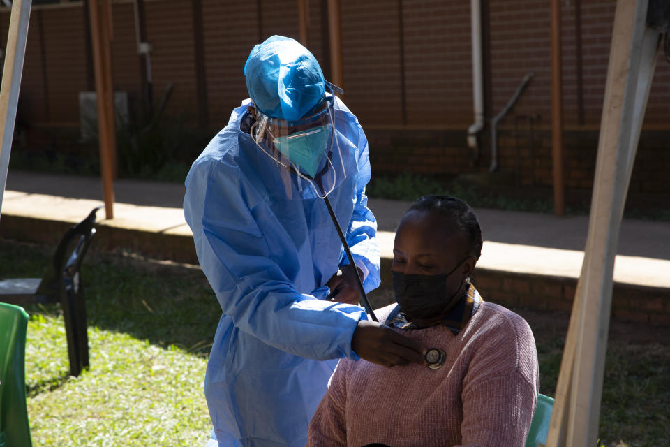 A woman is screened for COVID-19 at a testing centre in Soweto, South Africa, Wednesday, May 11, 2022. Health experts in South Africa say the country is experiencing a surge of new COVID-19 cases driven by two omicron sub-variants. Professor Marta Nunes, a researcher at Vaccine and Infectious Diseases Analytics at Chris Hani Baragwanath Hospital in Soweto said that for about three weeks the country has seen increasing numbers of new cases and somewhat higher hospitalizations, but not increases in severe cases and deaths. (AP Photo/Denis Farrell)