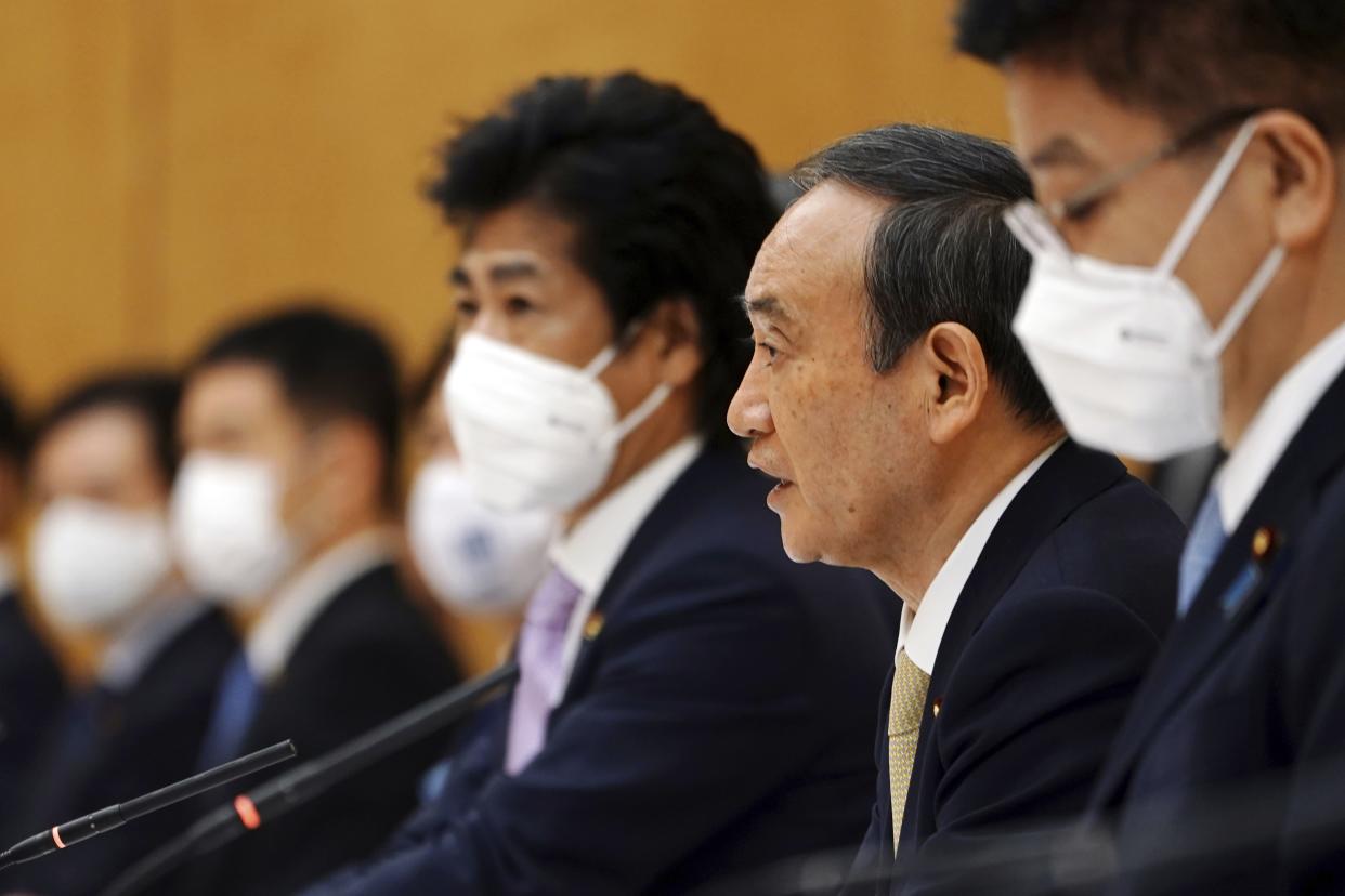 Japanese Prime Minister Yoshihide Suga, second right, declares a state of emergency for Tokyo and three other prefectures during the government task force meeting for the COVID-19 measures at the prime minister's office Friday, April 23, in Tokyo. 