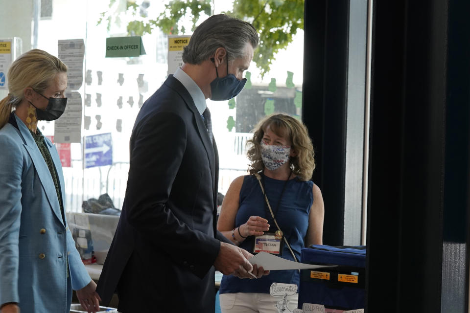 California Gov. Gavin Newsom, casts his ballot for the recall election at a voting center in Sacramento, Calif., Friday, Sept. 10, 2021. Newsom was accompanied by his wife, First Partner Jennifer, Siebel Newsom, left. The last day to vote in the recall election is Tuesday Sept. 14. A majority of voters must mark "no" on the recall to keep Newsom in office. (AP Photo/Rich Pedroncelli)