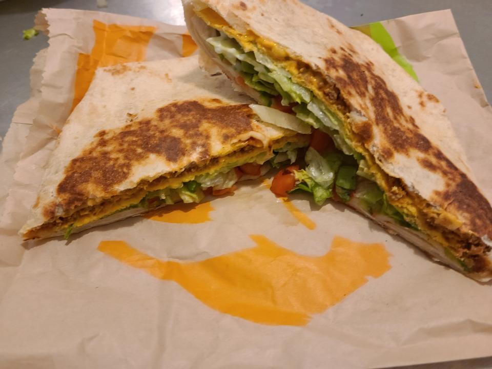 crunchwrap supreme from taco bell sitting on its wrapper