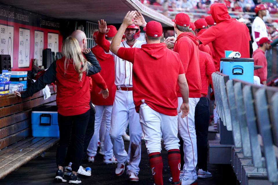 Cincinnati Reds right fielder Wil Myers (4) is congratulated in the dugout after scoring in the first inning of a baseball game between the Chicago Cubs and the Cincinnati Reds, Monday, April 3, 2023, at Great American Ball Park in Cincinnati. 