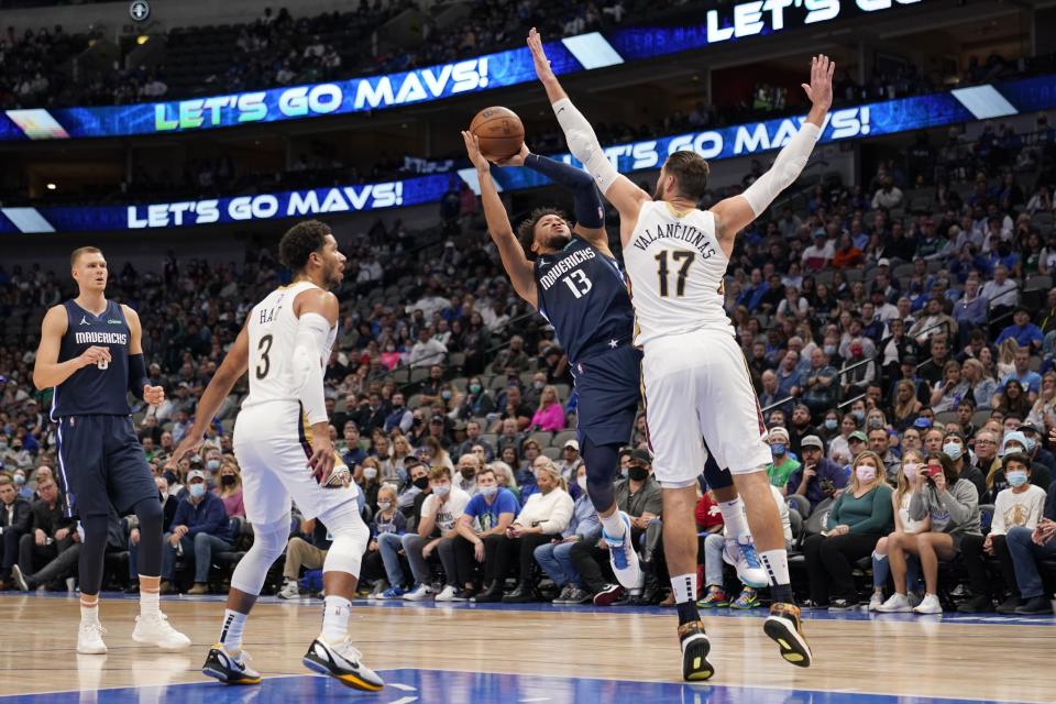 Dallas Mavericks' Jalen Brunson (13) shoots over New Orleans Pelicans center Jonas Valanciunas (17) as Mavericks' Kristaps Porzingis, left, and Pelicans' Josh Hart (3) look on in the second half of an NBA basketball game in Dallas, Monday, Nov. 8, 2021. (AP Photo/Tony Gutierrez)