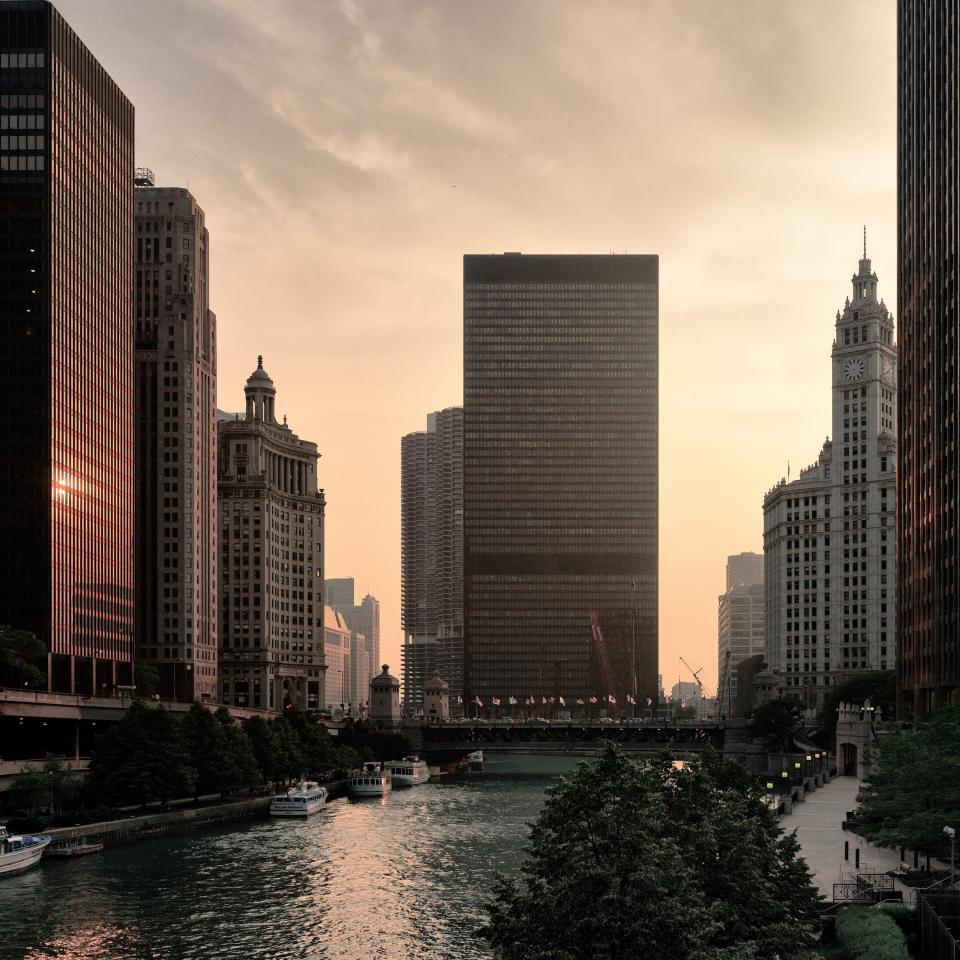 Mies van der Rohe's iconic IBM Building rises above the Chicago River at dusk.