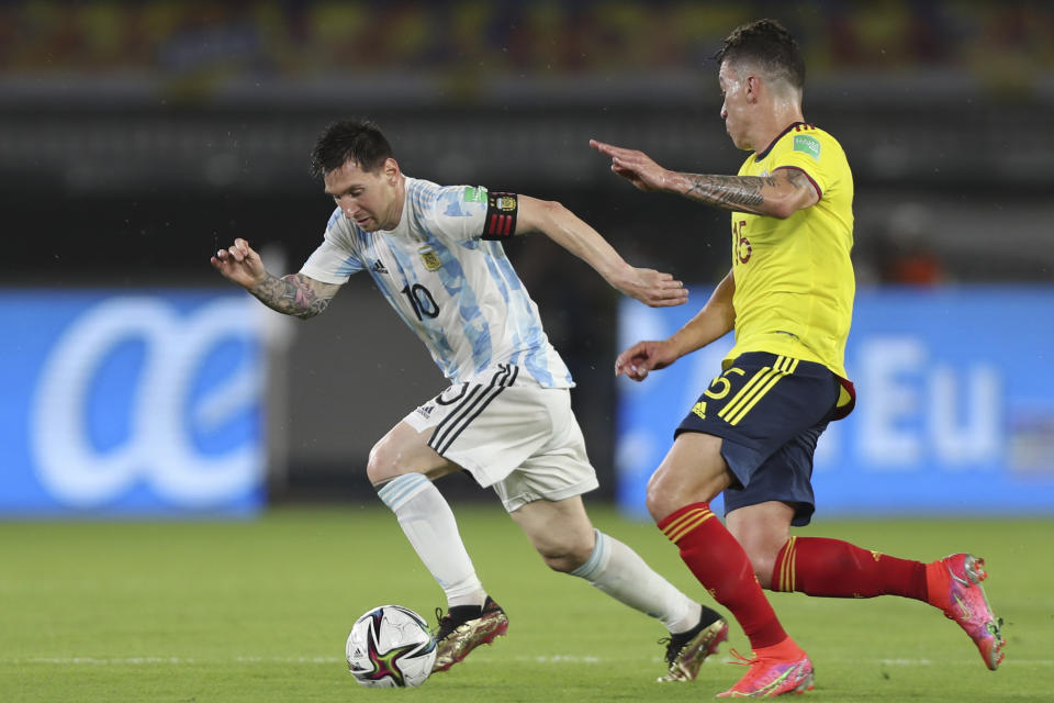 Colombia's Matheus Uribe chases Argentina's Lionel Messi during a qualifying soccer match for the FIFA World Cup Qatar 2022 at the Metropolitano stadium in Barranquilla, Colombia, Tuesday, June 8, 2021. (AP Photo/Fernando Vergara)