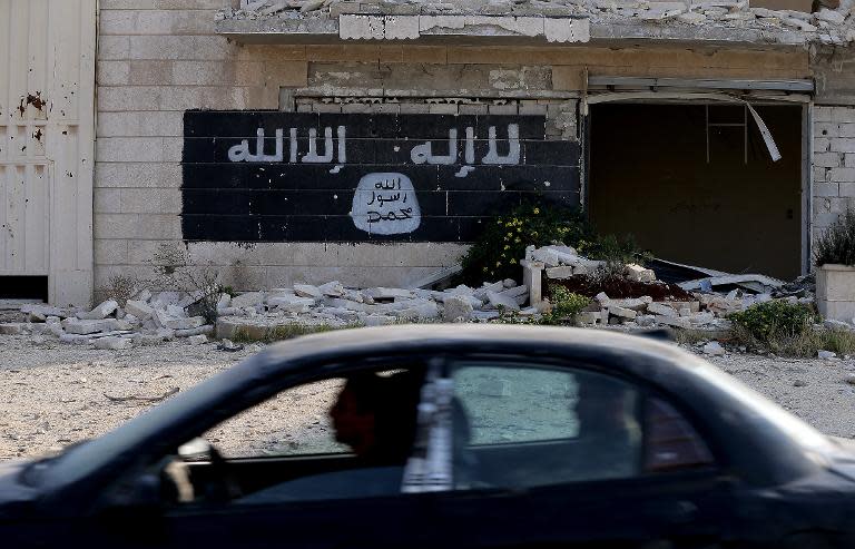Un grafiti de una bandera yihadista, en la pared de una fábrica derruida en la zona industrial de Alepo (Siria), el 18 de noviembre de 2014