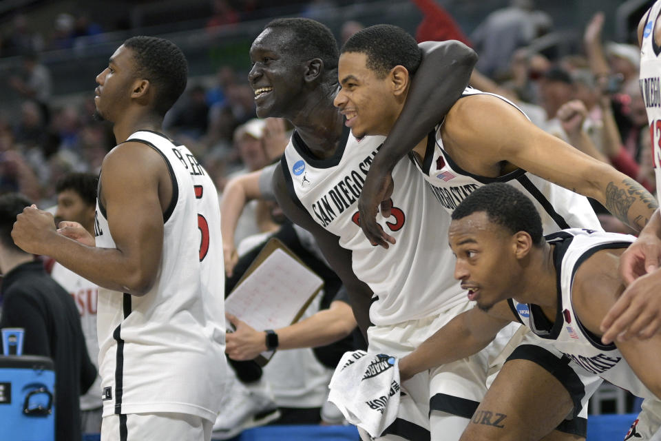 San Diego State guard Lamont Butler (5), forward Aguek Arop, forward Keshad Johnson and guard Micah Parrish, right, celebrate as time expires in their win against Furman in a second-round college basketball game in the NCAA Tournament, Saturday, March 18, 2023, in Orlando, Fla. (AP Photo/Phelan M. Ebenhack)