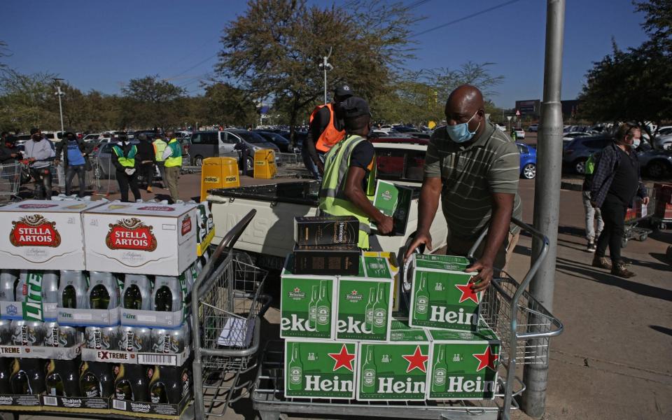 Workers help a customer load alcohol in to his van in Pretoria - PHILL MAGAKOE/AFP