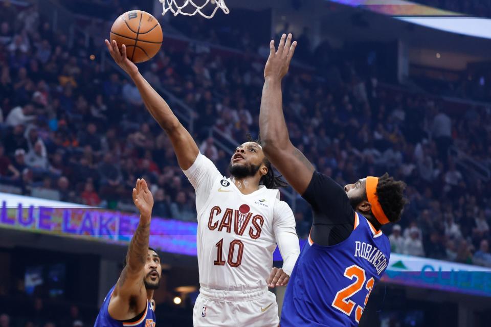 Cleveland Cavaliers guard Darius Garland (10) shoots against New York Knicks center Mitchell Robinson (23) during the first half of an NBA basketball game Friday, March 31, 2023, in Cleveland. (AP Photo/Ron Schwane)