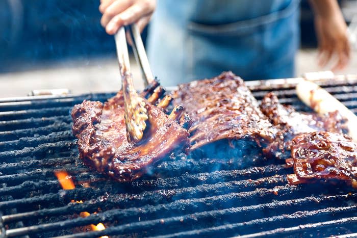 Man cooking BBQ pork ribs on the grill.