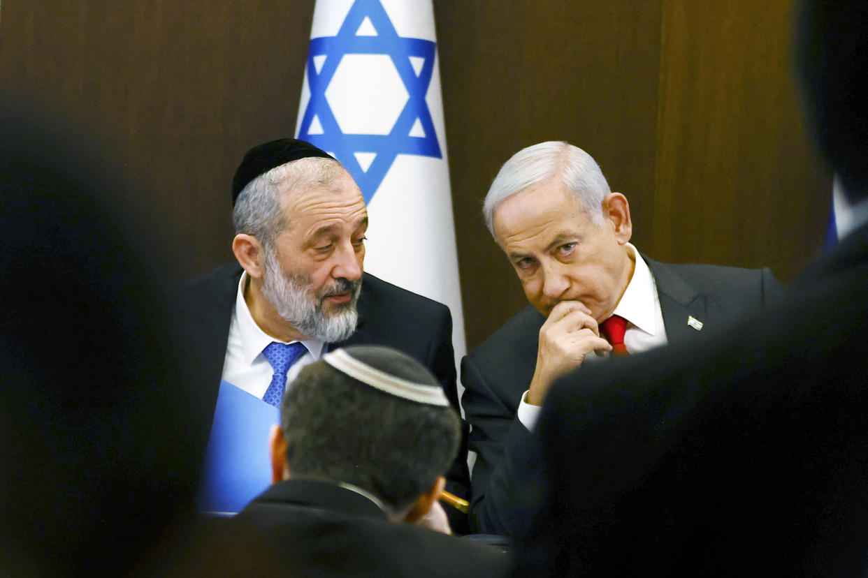 Israeli Prime Minister Benjamin Netanyahu, right, speaks with Interior and Health Minister Aryeh Deri at a weekly cabinet meeting at the Prime Minister's office in Jerusalem, Sunday, Jan. 8, 2023. (Ronen Zvulun/Pool Photo via AP)