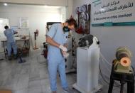 Abdelmawla Ibrahim, a Syrian amputee and physical therapist, works on a prosthetic at Al-Bab centre for prosthetics in Al-Bab