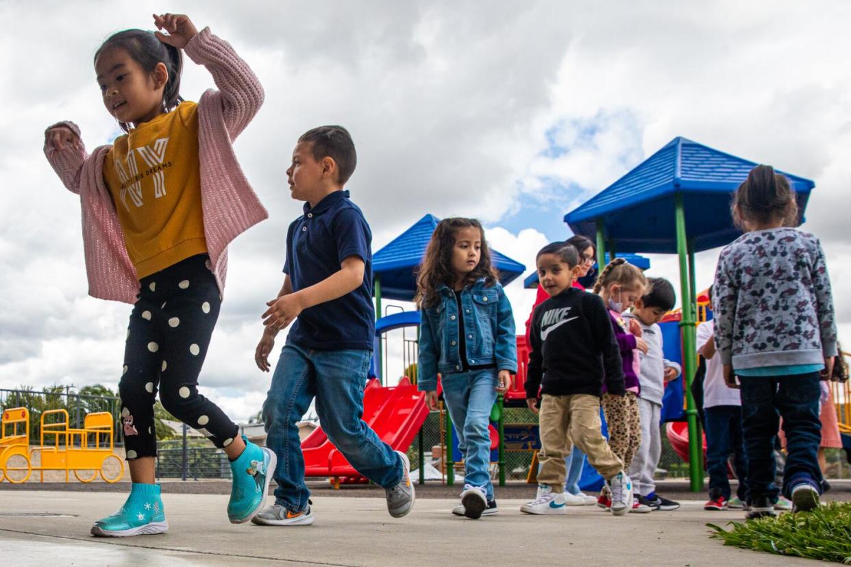 Young children line up on a playground.