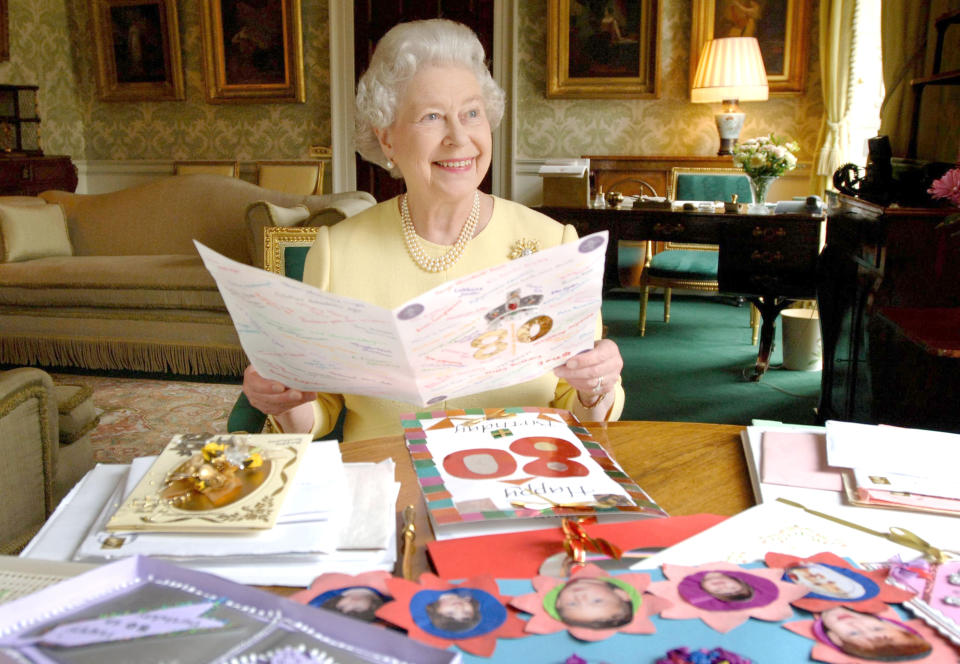 HM Queen Elizabeth II sits in the Regency Room at Buckingham Palace in London, April 20, 2006, as she looks at some of the cards which have been sent to her for her 80th birthday. (Photo by Anwar Hussein Collection/ROTA/WireImage)