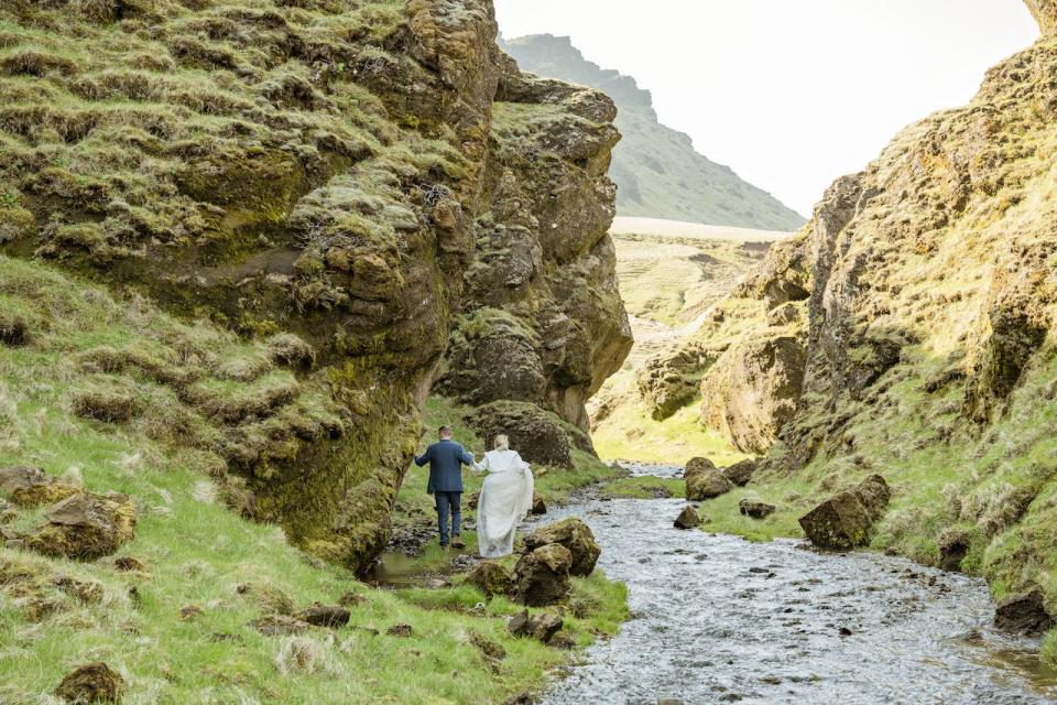 A bride and groom take wedding photos in a canyon in Iceland.