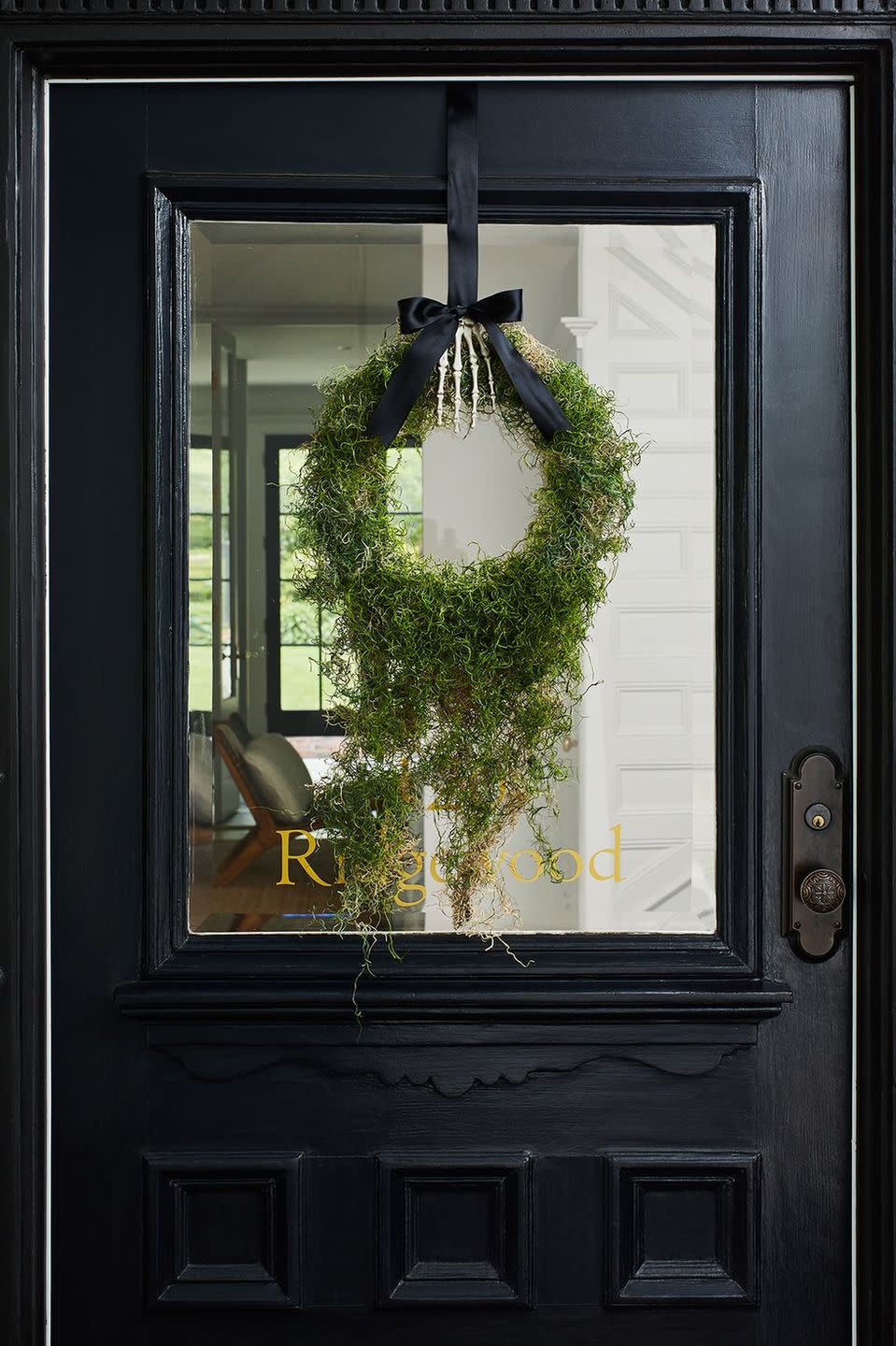 <p>Cover a wreath form with dripping moss and suspend from your front door with a spooky skeleton hand and black ribbon for an elegantly understated creepy decoration.</p>