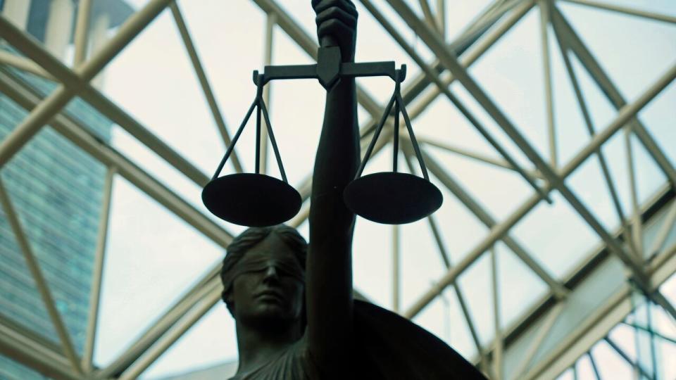 A statue of Lady Justice, blindfolded and holding balanced scales, resides at Vancouver's Supreme Court building. 