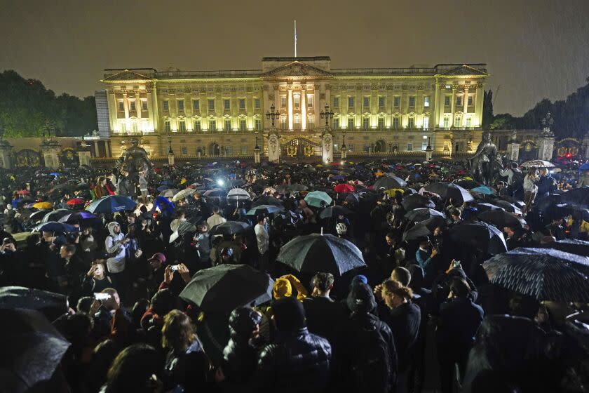 People gather outside Buckingham Palace following the announcement of the death of Queen Elizabeth II, in London, Thursday, Sept. 8, 2022. (Victoria Jones/PA via AP)