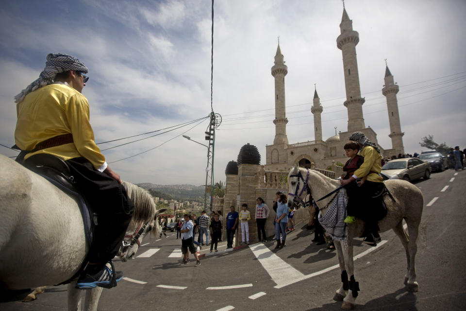 Palestinian ride their horses near a new mosque, partially funded by Chechnya, in the Arab village of Abu Ghosh, on the outskirts of Jerusalem, Sunday, March 23, 2014. Isa Jabar, the mayor of the village, says Chechnya donated $6 million for the new mosque and that some Abu Ghosh residents trace their ancestry to 16th century Chechnya and the Caucus region. (AP Photo/Sebastian Scheiner)