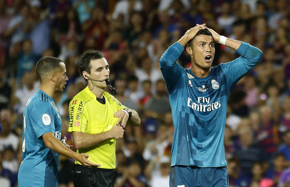 Real Madrid’s Cristiano Ronaldo, right, reacts after Referee Ricardo de Burgos shows a yellow card during the Spanish Supercup, first leg, soccer match between FC Barcelona and Real Madrid at the Camp Nou stadium in Barcelona, Spain, Sunday, Aug. 13, 2017. (AP Photo/Manu Fernandez)
