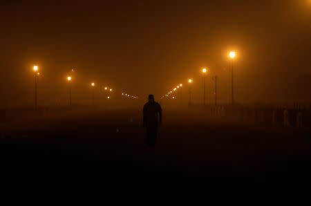 A man wearing a protective mask walks amidst smog in the early morning in New Delhi, India, November 8, 2018. REUTERS/Anushree Fadnavis