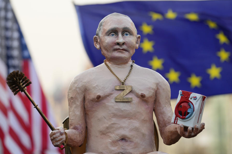 People hold up a statue depicting Russian President Vladimir Putin as tens of thousands of people gathers for an anti-war protest in Prague, Czech Republic, Sunday, Oct. 30, 2022. (AP Photo/Petr David Josek)