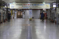 A man wearing a face mask as a precaution against the coronavirus walks through an underground shopping mall in Seoul, South Korea, Sunday, Nov. 29, 2020. South Korea is shutting down indoor gyms offering intense workout classes and banning year-end parties at hotels in the greater Seoul area to fight the virus. Prime Minister Chung Sye-kyun said Sunday.(AP Photo/Ahn Young-joon)