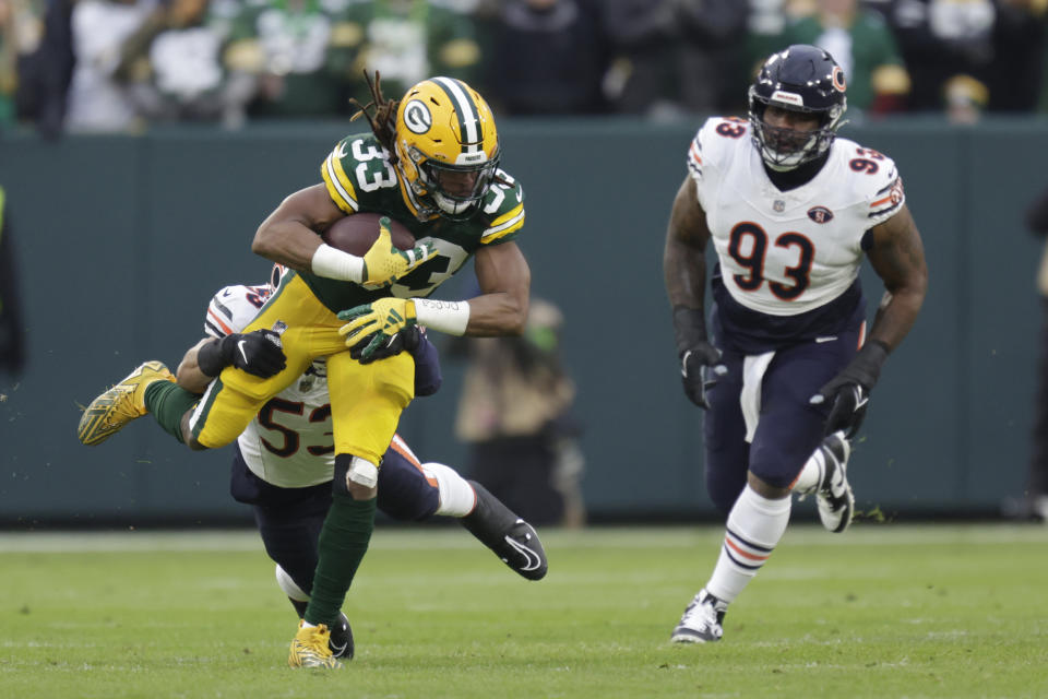 Green Bay Packers running back Aaron Jones (33) catches a pass for a first down as Chicago Bears linebacker T.J. Edwards (53) and defensive tackle Justin Jones (93) defend during the first half of an NFL football game Sunday, Jan. 7, 2024, in Green Bay, Wis. (AP Photo/Matt Ludtke)