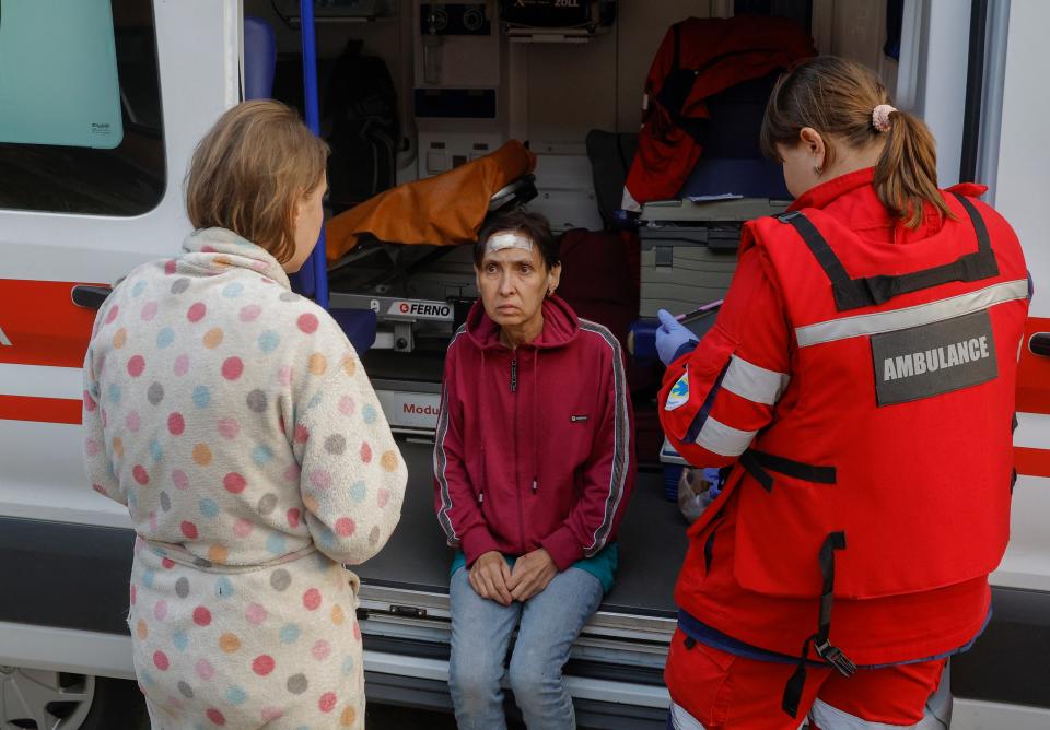 A medical worker assists an injured woman in Kyiv (EPA)