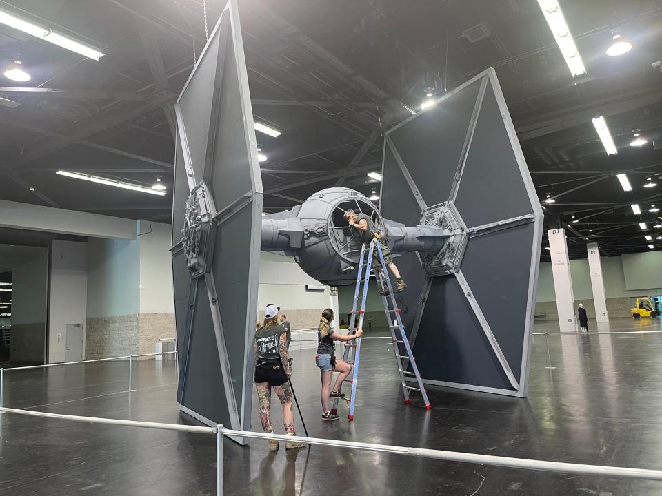 A team prepares a Galactic Empire TIE fighter display at 
Star Wars Celebration at the Anaheim Convention Center. The four-day event ends on Sunday.