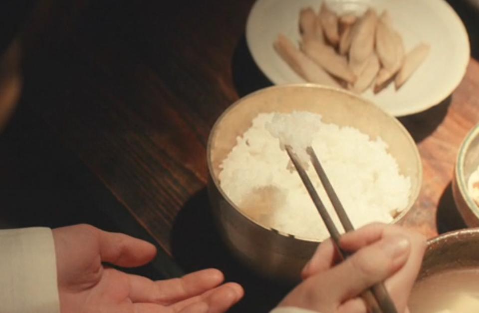 Sunja eating the precious rice her mother bought