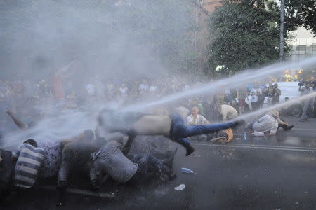 Protesters are hit by a jet of water released from a riot police vehicle during a rally against a recent decision to increase the tariff on electricity, in Yerevan, Armenia, June 23, 2015. REUTERS/Narek Aleksanyan/PAN Photo