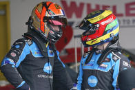 Alexander Rossi, left, and Filipe Albuquerque, of Portugal, talk in their garage during a practice session for the Rolex 24 hour auto race at Daytona International Speedway, Friday, Jan. 28, 2022, in Daytona Beach, Fla. (AP Photo/John Raoux)