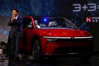 Foxconn Chairman Liu Young-way poses on stage with an electric vehicle, the Model C, during the company's annual Tech Day in Taipei