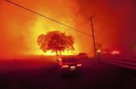 RNPS - PICTURES OF THE YEAR 2013 - Residents flee as winds whip flames from the Morgan fire along Morgan Territory Road near Clayton, California in unincorporated Contra Costa County September 9, 2013. The blaze, burning in dense, dry scrub, grass and timber in and around Mount Diablo State Park, had scorched some 3,700 acres (1,500 hectares) by Monday afternoon, forcing the evacuation of about 100 homes at the edge of the town of Clayton. REUTERS/Noah Berger (UNITED STATES - Tags: DISASTER ENVIRONMENT SOCIETY TPX)