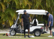 Tiger Woods, left, sets a ball during a practice session at the Albany Golf Club, in New Providence, Bahamas, Saturday, Dec. 4, 2021. Fitness instructor Kolby Wayne is pictured right. (AP Photo/Fernando Llano)