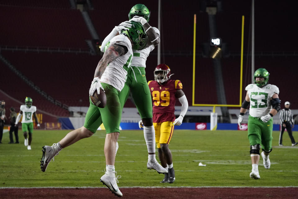 Oregon tight end Hunter Kampmoyer (48) celebrates a touchdown with wide receiver Devon Williams (2) during the first quarter of an NCAA college football game for the Pac-12 Conference championship against Southern California, Friday, Dec 18, 2020, in Los Angeles. (AP Photo/Ashley Landis)
