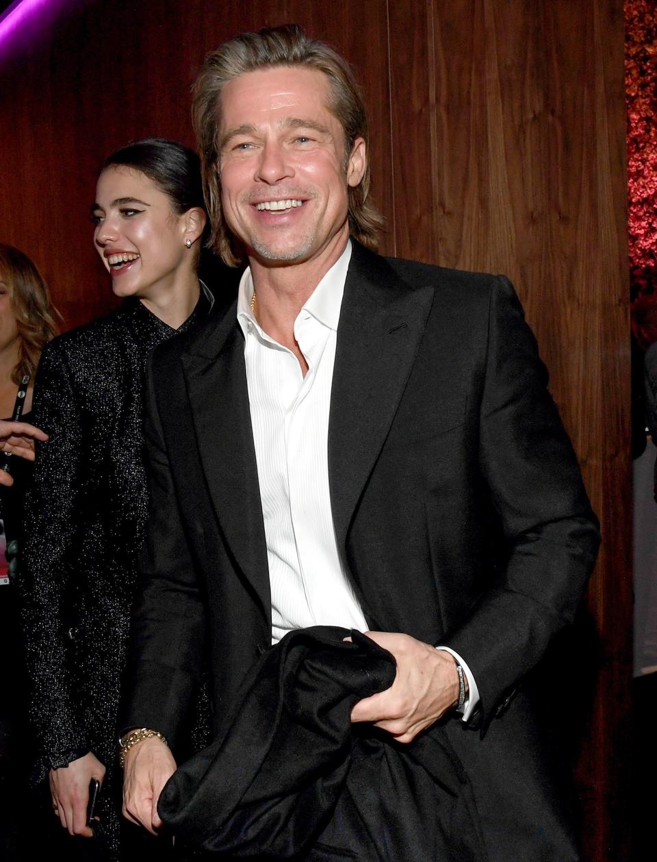 There goes Brad Pitt (with Margaret Qualley behind him), <a href="https://people.com/awards/sag-awards-2020-brad-pitt-jokes-about-his-tinder-profile-and-more-of-the-nights-best-quotes/" rel="nofollow noopener" target="_blank" data-ylk="slk:off to update his Tinder profile;elm:context_link;itc:0;sec:content-canvas" class="link ">off to update his Tinder profile</a>!