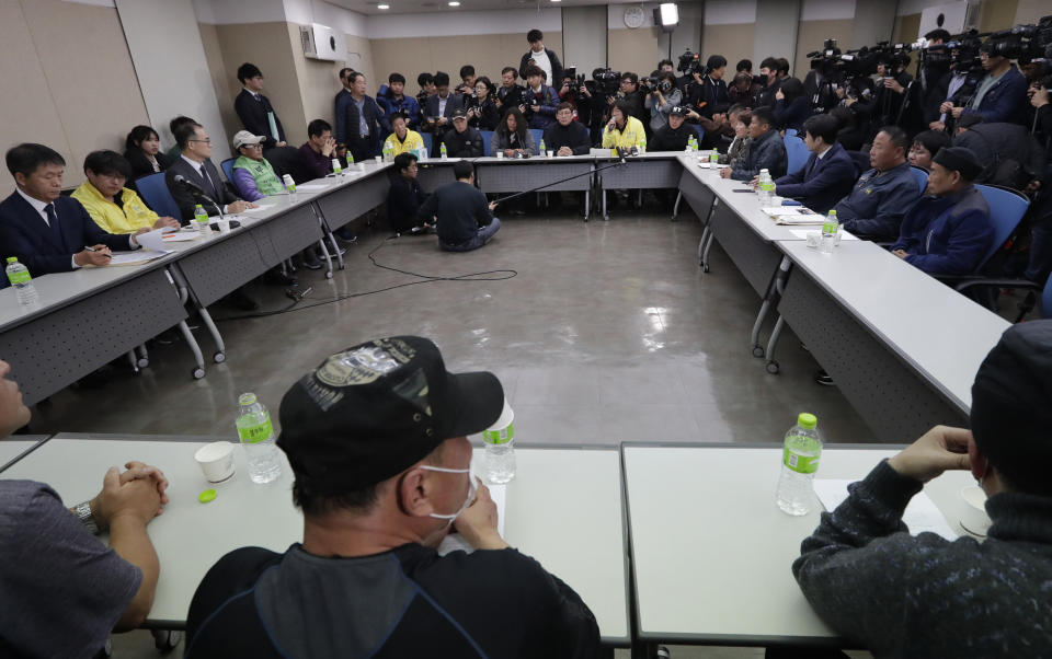 South Korea's Prosecutor General Moon Moo-il, third from left, meet with about a dozen former inmates in Seoul, South Korea, Tuesday, Nov. 27, 2018. On Tuesday Moon apologized over what he described as a botched investigation into the enslavement and mistreatment of thousands of people at a vagrants' facility in the 1970s and 1980s nearly three decades after its owner was acquitted of serious charges. (AP Photo/Lee Jin-man)