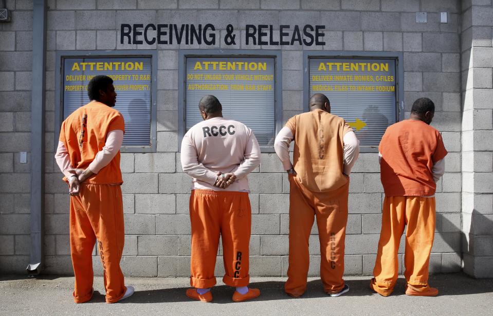 In this photo taken Thursday, Feb. 20, 2014, prisoners from Sacramento County await processing after arriving at the Deuel Vocational Institution in Tracy, Calif. California counties are thwarting the state's efforts to comply with a federal court order to reduce it's inmate population by sending state prisons far more convicts than anticipated including a record number of second-strikers. The state is trying to comply with a landmark restructuring of its criminal justice system through a nearly 3-year-old law pushed by Gov. Jerry Brown that keeps lower-level felons in county jails while reserving scarce state prison cells for serious, violent and sexual offenders.(AP Photo/Rich Pedroncelli)