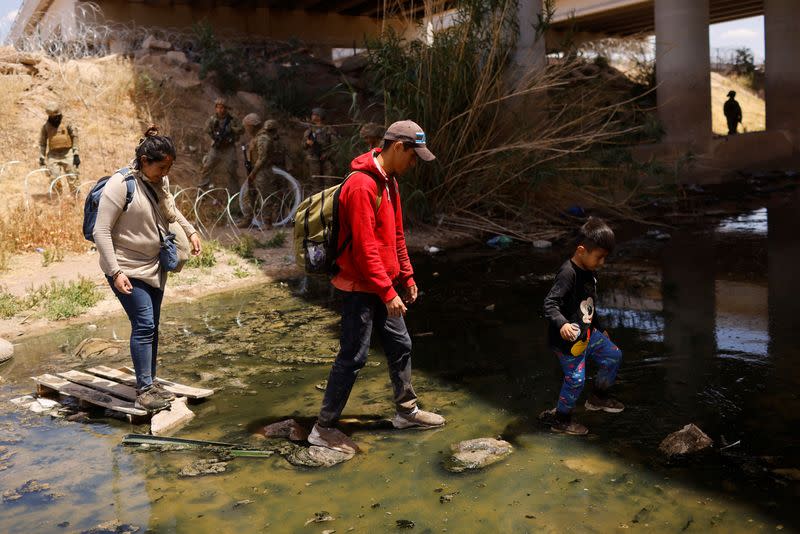 Migrants seeking asylum cross the Rio Bravo river, to return to Mexico from the United States, as seen from Ciudad Juarez