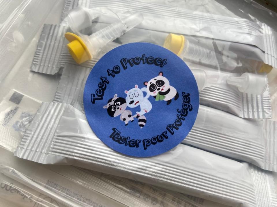 A sticker on a bag of COVID-19 rapid take-home tests encourages people to 'test to protect.' (Frances Willick/CBC - image credit)