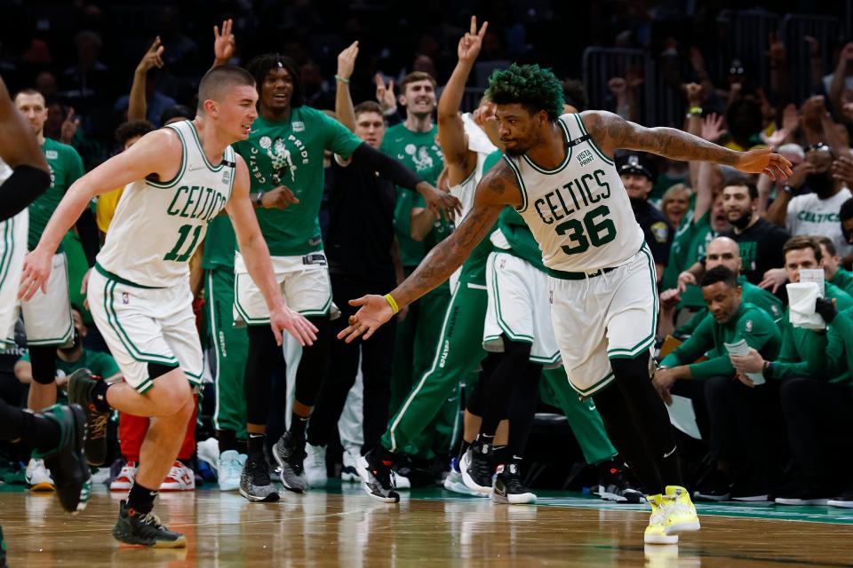 The Celtics' Marcus Smart (36) and Payton Pritchard  celebrate after a three-point basket against the Bucks during Game 7.