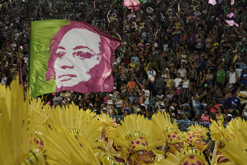 A flag waves an image of the slain councilwoman Marielle Franco during the perform of the Mangueira samba school during Carnival celebrations at the Sambadrome in Rio de Janeiro, Brazil, Tuesday, March 5, 2019. (AP Photo/Leo Correa)