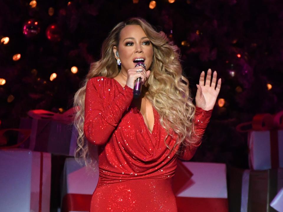 Mariah Carey singing in a red sparkling dress.