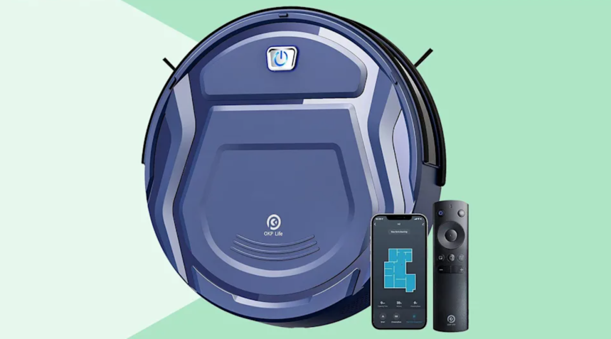 A blue robot vacuum with a black remote and smartphone next to it