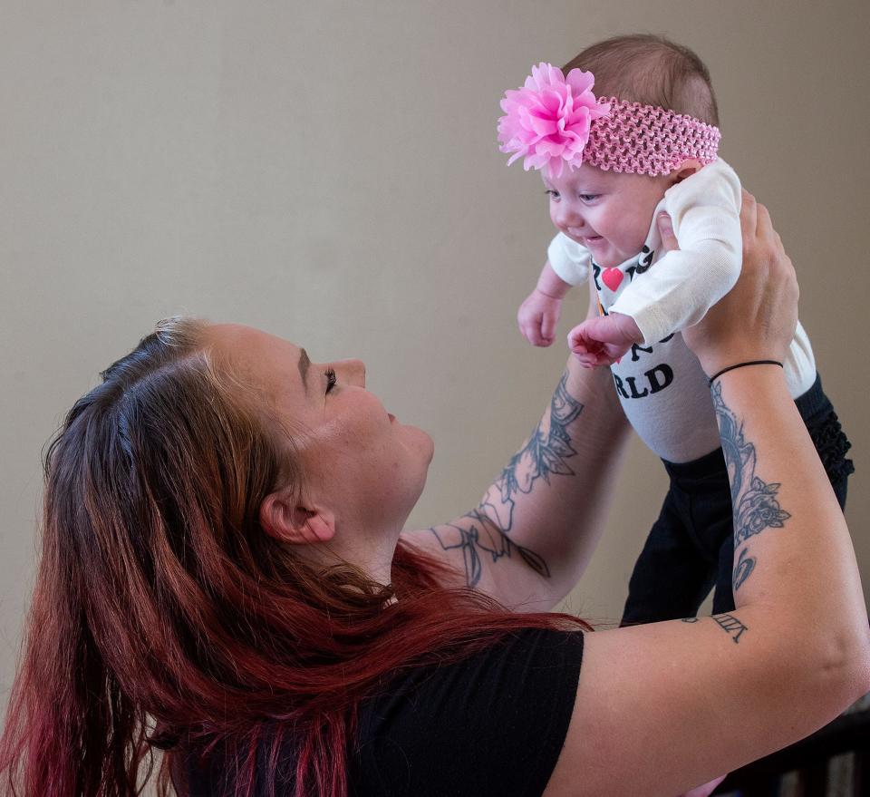 Patricia, holds up her daughter, Annalyce, three months, inside their home in Bristol Township, on Friday, Nov. 18,. 2022