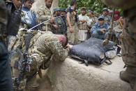 <p>U.S. Army Captain Michael Kelvington, commander of the Battle company, 1-508 Parachute Infantry battalion, 4th Brigade Combat Team, 82nd Airborne Division, bows next to remains of Gulam Dostager, a member of Afghan Local Police who was killed in the blast of an Improvised Explosive Device (IED) during the joint Tor Janda (Black Flag in Pashtu) operation, in Zahri district of Kandahar province, southern Afghanistan on May 25, 2012. (Photo: Shamil Zhumatov/Reuters) </p>